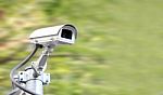 Security Camera On Blur Green Plant Background Stock Photo