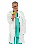 Senior Doctor holding Green Apple Stock Photo