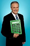 Senior Executive Posing With Big Green Calculator Stock Photo