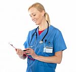 Senior Female Doctor Writing Report Stock Photo