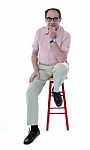 Senior Man Resting On Stool Stock Photo