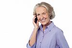 Senior Smiling Lady Attending Phone Call Stock Photo