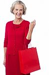 Senior Woman Holding Red Shopping Bag Stock Photo