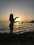 Sexy Woman Silhouette Standing In The Sand During A Sunset On Golden Bay, Malta Stock Photo