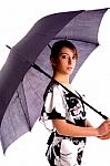 Side Pose Of Young Woman Holding An Umbrella Stock Photo