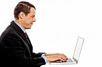 Side View Of Corporate Male Typing On Laptop Stock Photo