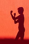 Silhouette Of Woman Showing Fists On Red Wall Stock Photo