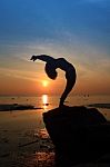 Silhouette Yoga Girl By The Beach At Sunrise Stock Photo