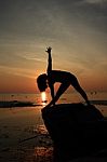 Silhouette Yoga Girl By The Beach At Sunrise Stock Photo