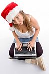 Sitting Female Wearing Christmas Hat And Holding Laptop Stock Photo