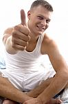 Sitting Young Man Showing Thumb Up Stock Photo