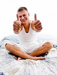 Sitting Young Man Showing Thumb Up Stock Photo