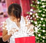 Small Girl Looking At Xmas Gift Stock Photo