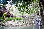 Small Waterfall Flowing Into A Calm Pool Of Water Stock Photo