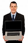 Smart Businessman Displaying Laptop To You Stock Photo