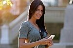 Smiling Beautiful Woman Texting With Her Phone In The Garden Stock Photo