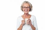 Smiling Bespectacled Old Lady Drinking Coffee Stock Photo