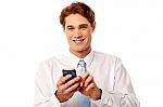 Smiling Business Executive Using Mobile Phone Stock Photo