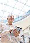 Smiling Businessan With Tablet Computer In Modern Business Build Stock Photo