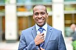 Smiling Businessman Adjusting His Tie Stock Photo