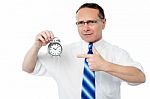 Smiling Businessman Holding An Alarm Clock Stock Photo