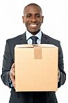 Smiling Businessman Holding Carton Box Stock Photo