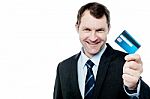 Smiling Businessman Holding Credit Card Stock Photo