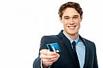 Smiling Businessman Offering His Debit Card To You Stock Photo