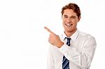 Smiling Businessman Pointing Away Stock Photo