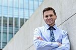 Smiling Businessman Standing Against Wall Stock Photo