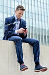 Smiling Businessman Using His Smartphone Stock Photo