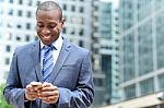 Smiling Businessman Using His Smartphone Stock Photo