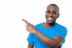 Smiling Casual Man Pointing Away Stock Photo