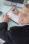 Smiling Ceo Writing on clipboard Stock Photo