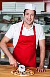 Smiling Chef Cutting Pizza With Cutter Stock Photo