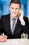 Smiling Corporate Guy Attending Phone Call Stock Photo