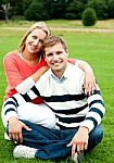 Smiling Couple Sitting In Outdoor Stock Photo