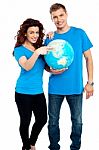 Smiling Couple Standing With Globe Stock Photo