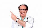 Smiling Doctor Pointing Upwards Stock Photo