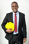 Smiling Engineer Holding A Hard Hat Stock Photo