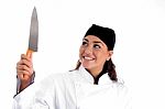 Smiling Female Chef Holding Knife Stock Photo