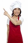 Smiling Female Chef Pointing Up Stock Photo