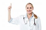 Smiling Female Doctor Pointing Upwards Stock Photo