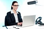 Smiling Female Secretary Working On Laptop Stock Photo