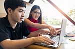 Smiling Friends With A Hot Drink Using Laptop In Cafe At The Uni Stock Photo