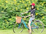 Smiling Girl Riding A Bicycle In The Park Stock Photo