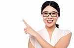 Smiling Girl Wearing Eyglasses Pointing Away Stock Photo