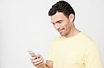 Smiling Guy Sending A Text Message Stock Photo