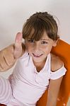 Smiling Little Girl Showing Thumb's Up Hand Gesture Stock Photo