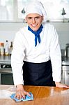 Smiling Male Chef Cleaning The Kitchen Table Stock Photo